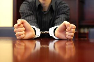 A criminal defense client in handcuffs waits for representation from a Phoenix lawyer.