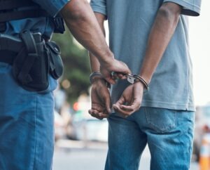person in handcuffs being led away