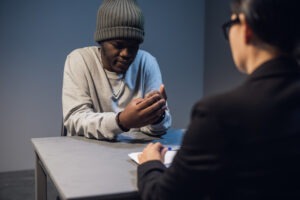 A defendant talks to a criminal defense attorney about the murder charges he is facing during a meeting. A criminal defense attorney helps with a murder charge by protecting the accused person’s rights at every stage of the case.