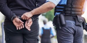 Man getting arrested by law enforcement, after which he will learn what happens when you’re arrested in Arizona, step-by-step.