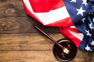 Federal and state charges in Phoenix illustrated with a judge’s gavel and an American flag.