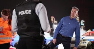 Police officer talking with a driver at a nighttime DUI stop