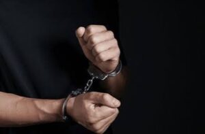 A man in handcuffs is taken away as his family wonders if they can call central intake & booking in Maricopa County for information.