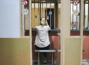 A woman sits in a booth and prepares to visit someone in 4th Avenue Jail in Phoenix.
