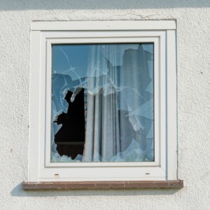 A broken window from criminal damage, which carries penalties under ARS 13-1602.